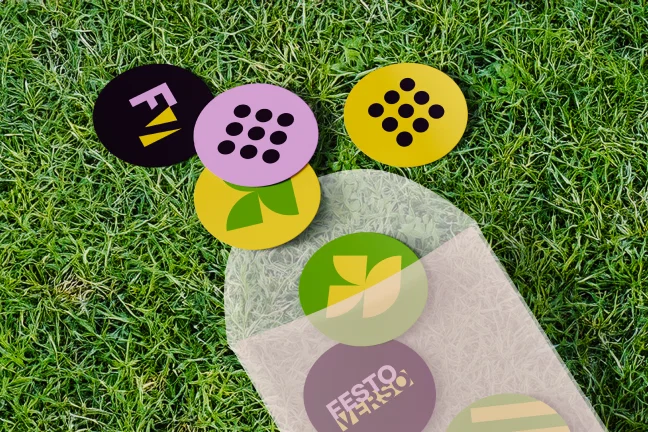 losse stickers dat naast en in een zakje liggen op een grasveld
